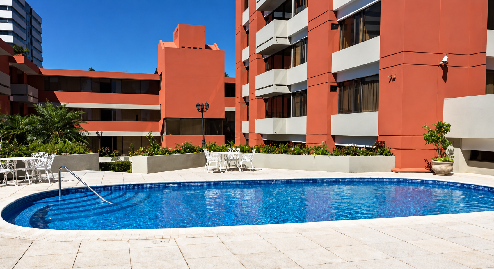 Piscina y jardín del edificio Villa Real